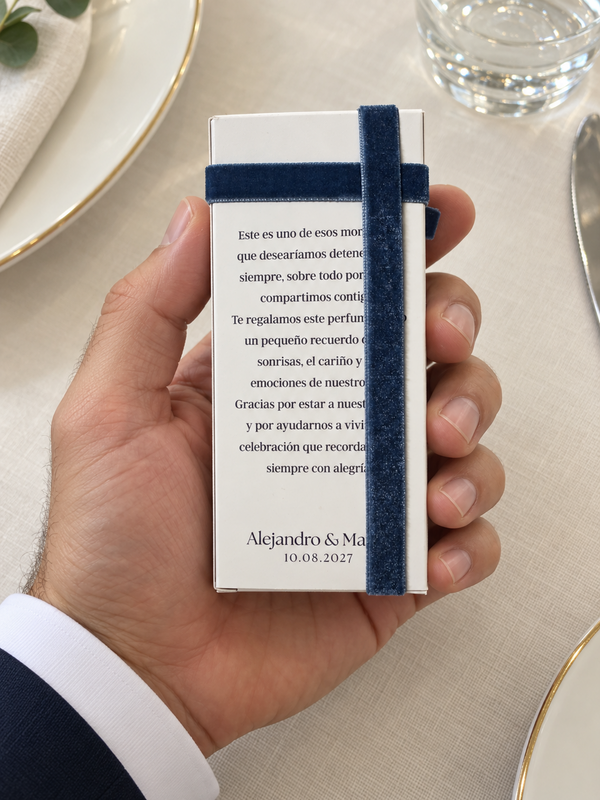 Detalle de la dedicatoria en una caja con lazo azul marino